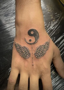 ying yang with wings tattoo